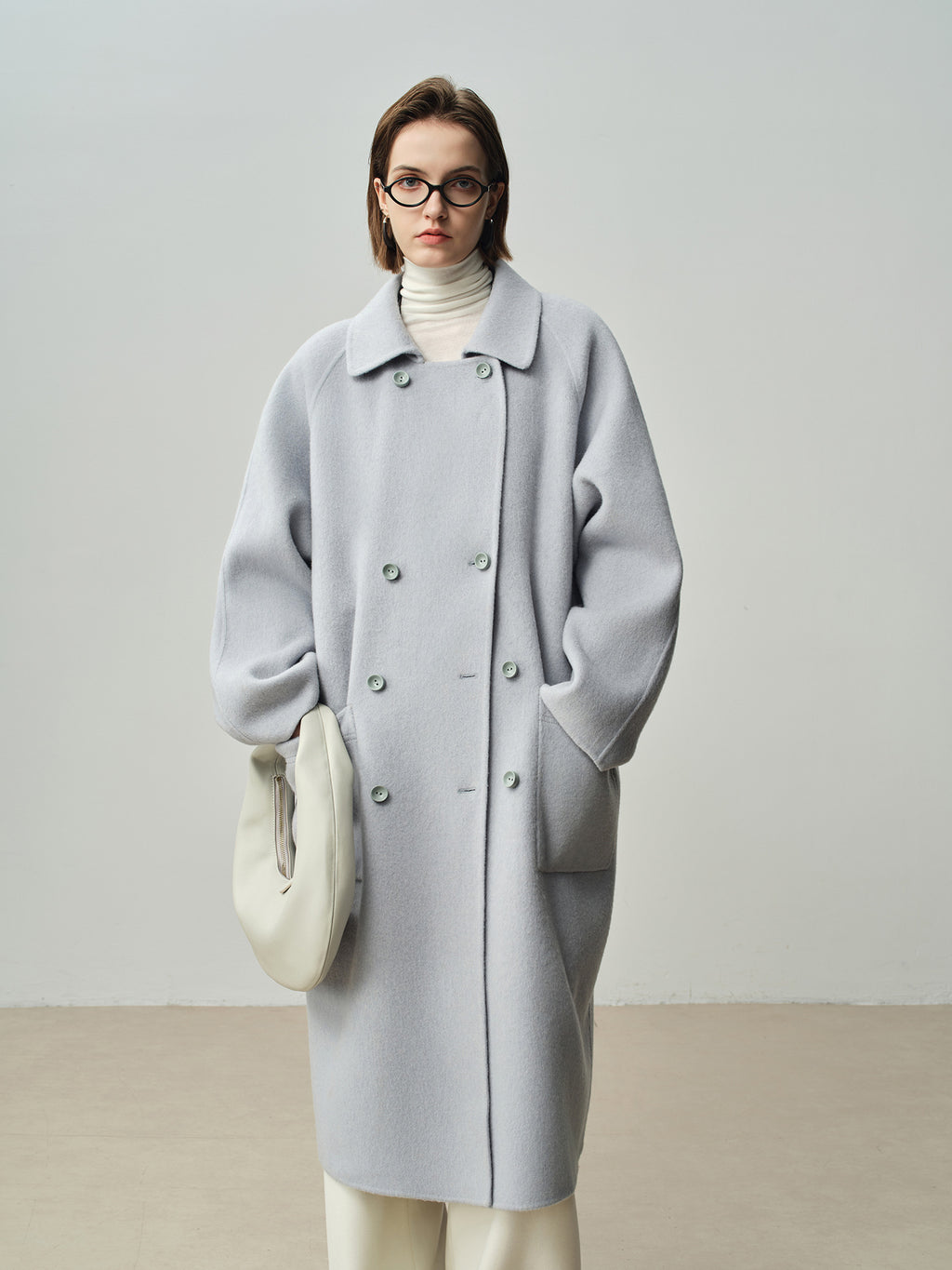 The Amaya Pastel Coat in light grey with oversized silhouette and elegant buttons for a chic look