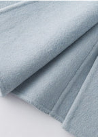 The Amaya Pastel Coat in soft blue fabric with a smooth texture and elegant drape