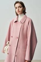The Amaya Pastel Coat in soft pink with a relaxed fit and double-breasted buttons, perfect for stylish layering.