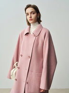 The Amaya Pastel Coat in soft pink, featuring a relaxed fit and large buttons for a stylish look