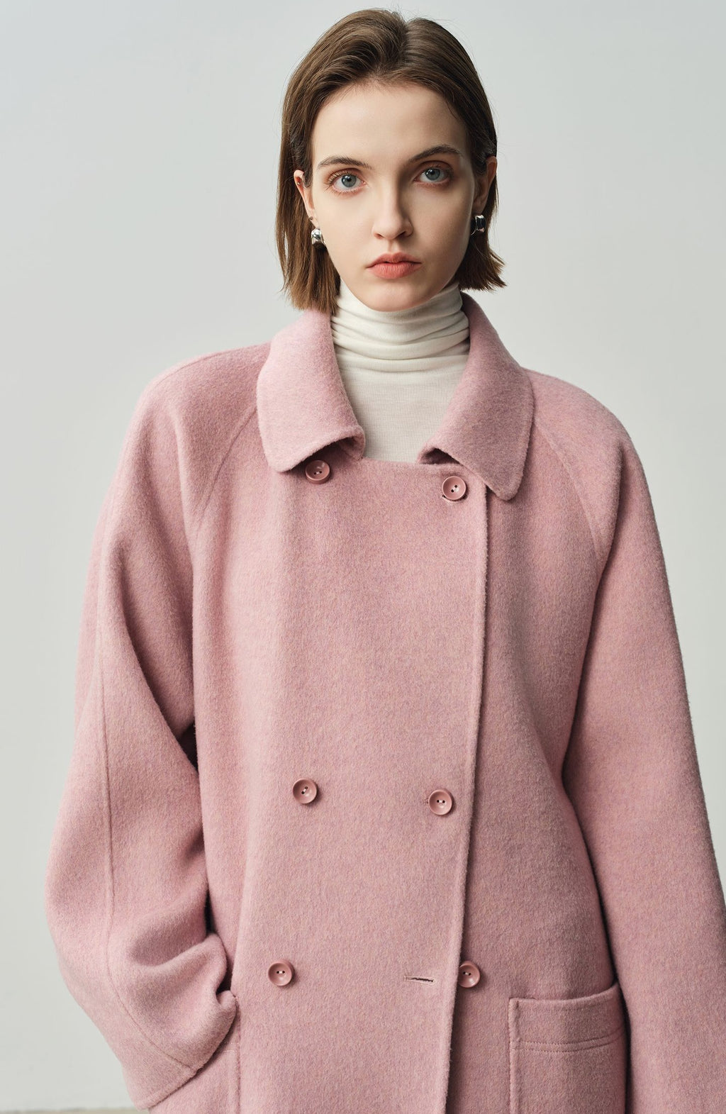 The Amaya Pastel Coat in soft pink with a double-breasted design and side pockets
