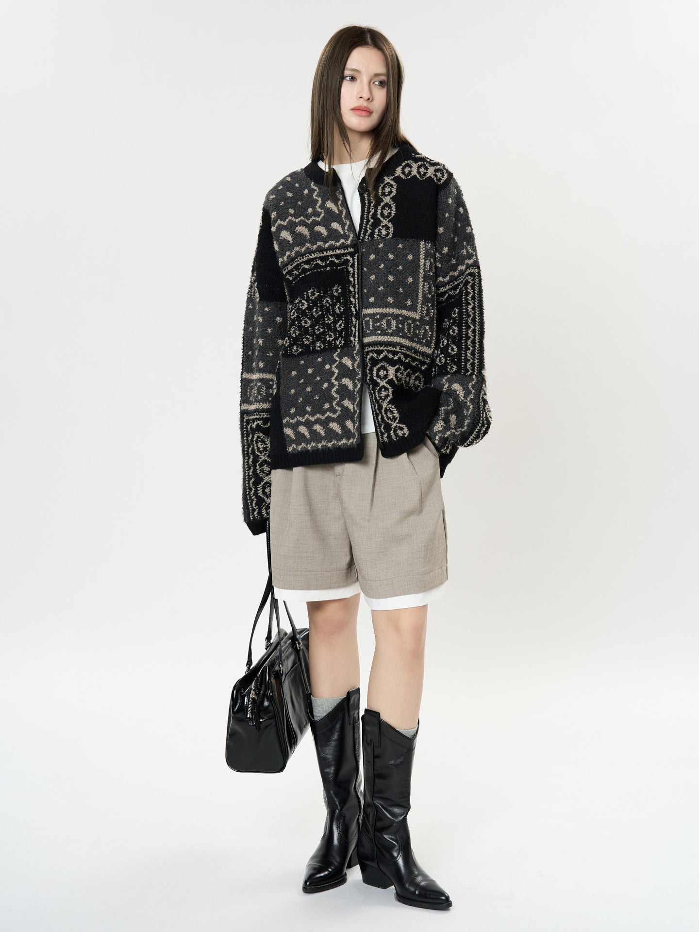 The Kyoto Jacquard Cardigan in black and cream with geometric patterns, paired with shorts and knee-high boots