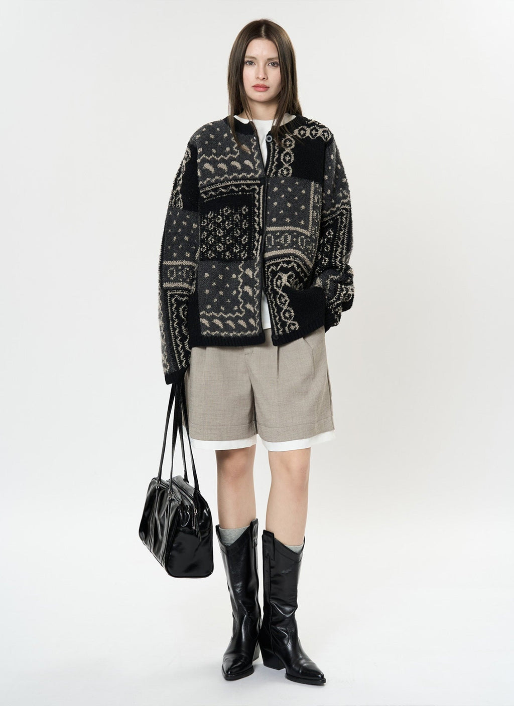The Kyoto Jacquard Cardigan in black and cream with unique pattern design, paired with shorts and boots