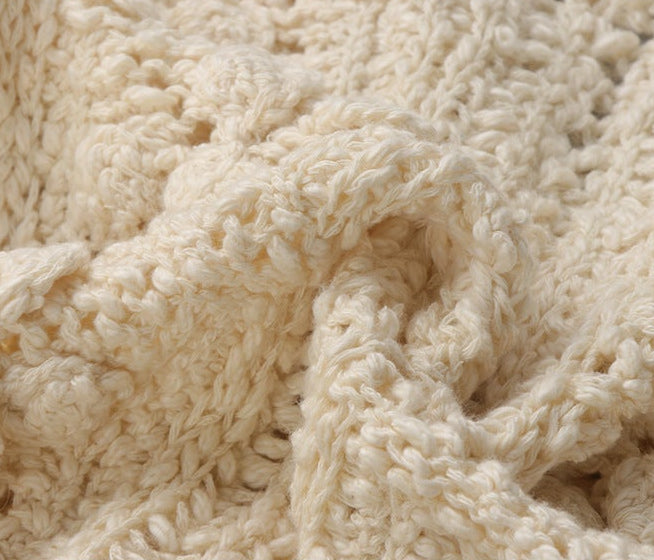 The Petale Knit, Hand Crocheted Wool Cardigan in soft cream color showcasing intricate texture and warmth