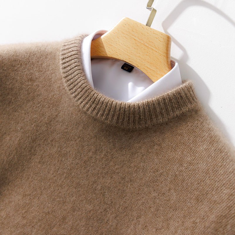 Thick Natural Wool Sweater With Elastic Hem hanging on a wooden hanger with a white shirt collar visible