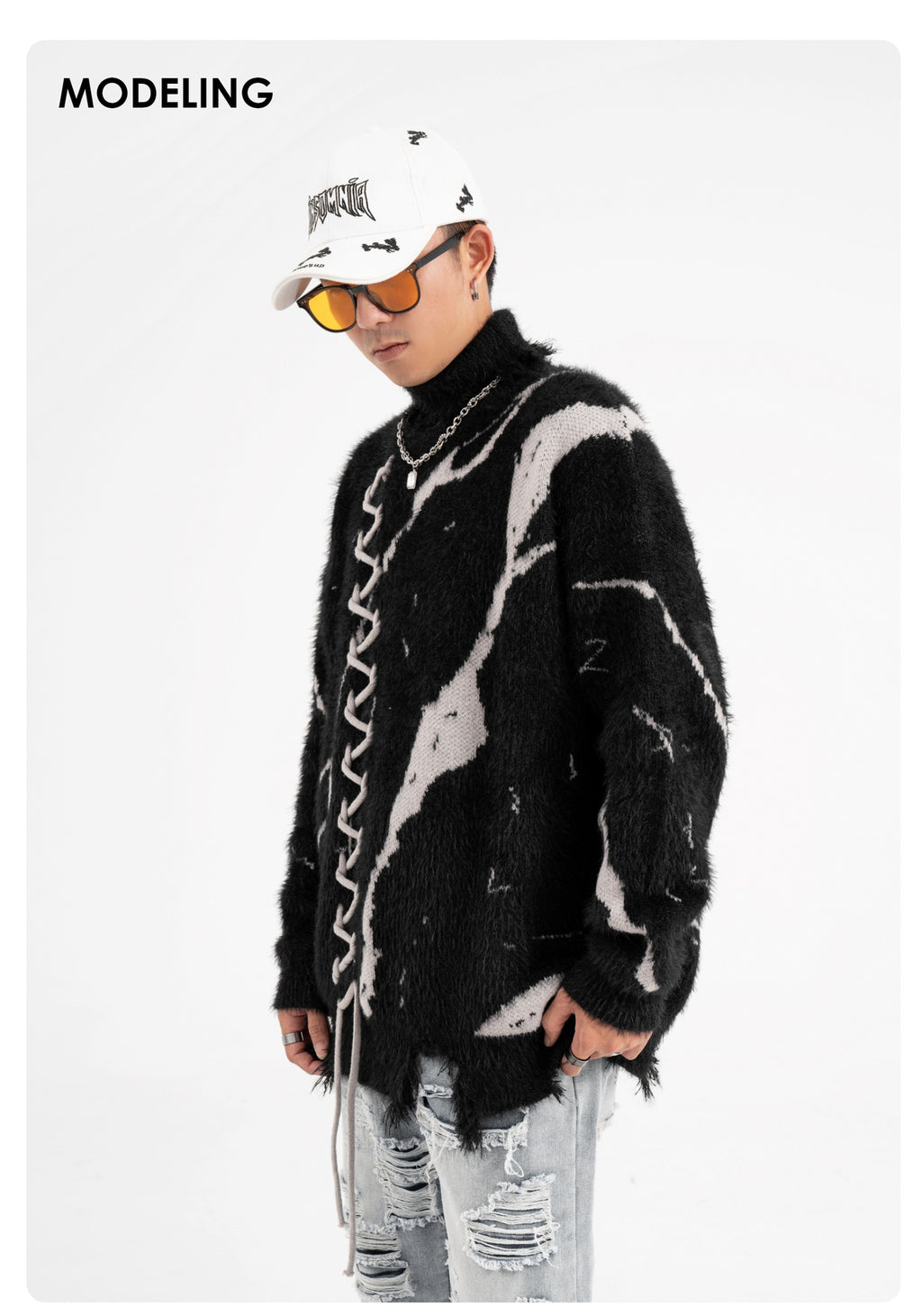 Model wearing an oversized sweater with dark street design and distressed details for urban fashion.