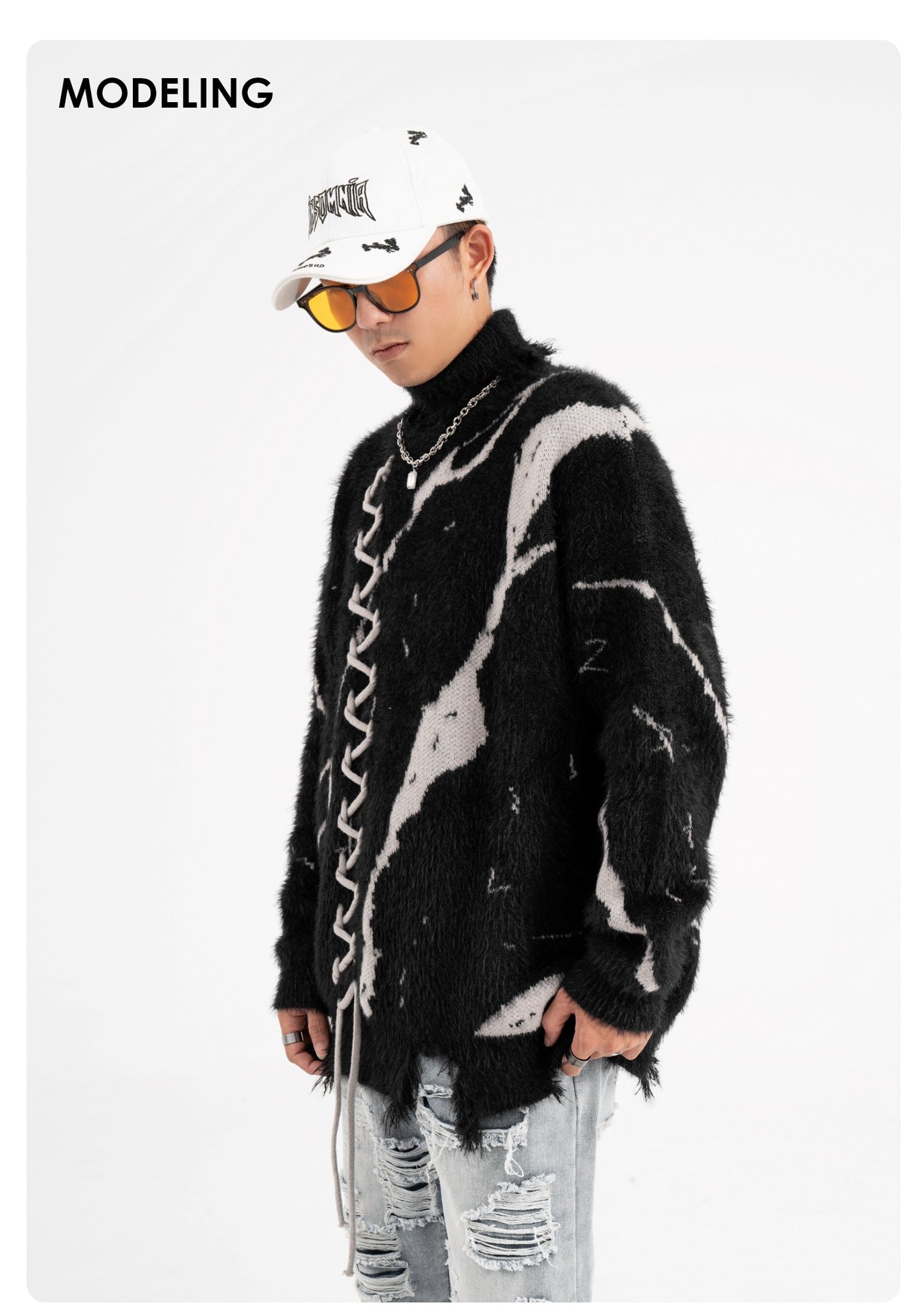 Model wearing an oversized sweater with dark street design and distressed details for urban fashion.