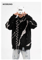 Model wearing oversized sweater with dark street design and distressed details for a trendy urban look