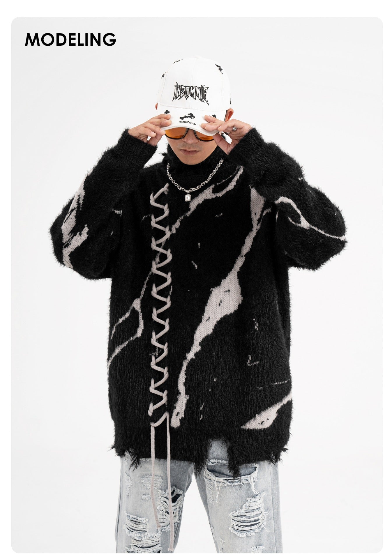 Model wearing oversized sweater with dark street design and distressed details for a trendy urban look