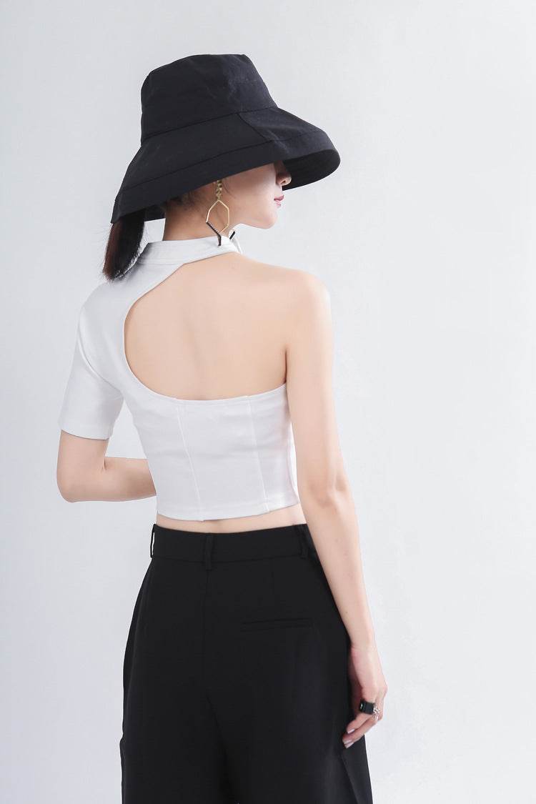 Top asimetric cu decupaje alb purtat de femeie cu pantaloni negri si palarie neagra