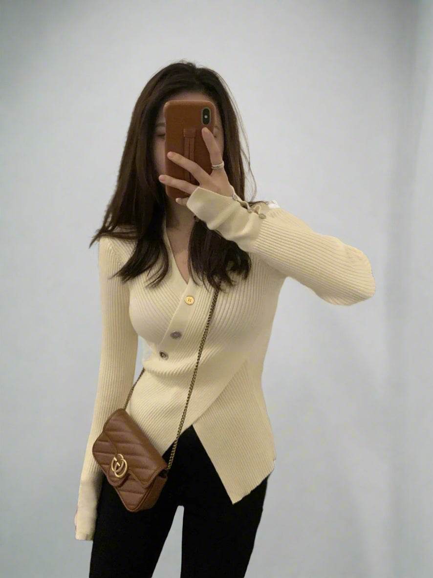 Woman wearing slim-fit ribbed asymmetric top with buttons and brown crossbody bag taking selfie