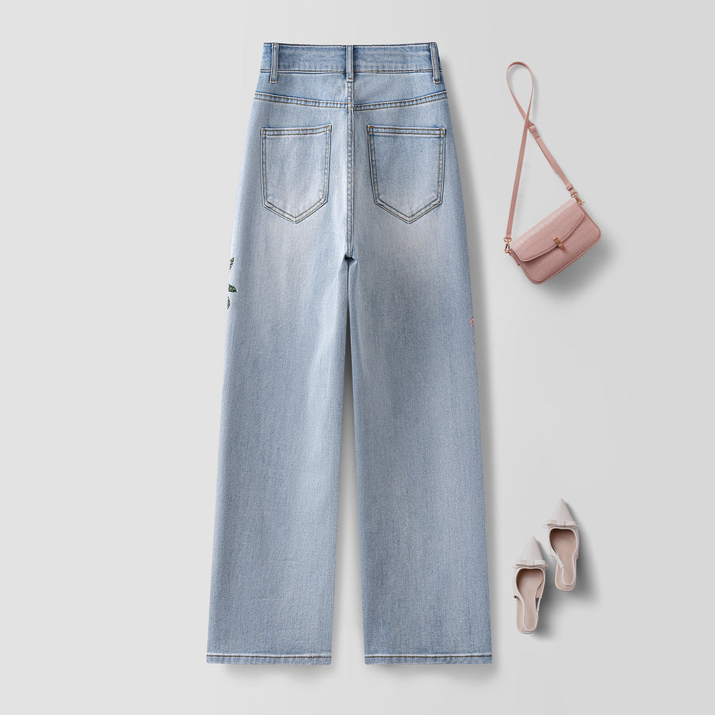 Twin Blossom Wide Leg Jeans in light blue with stylish back pockets and paired with a pink handbag and shoes