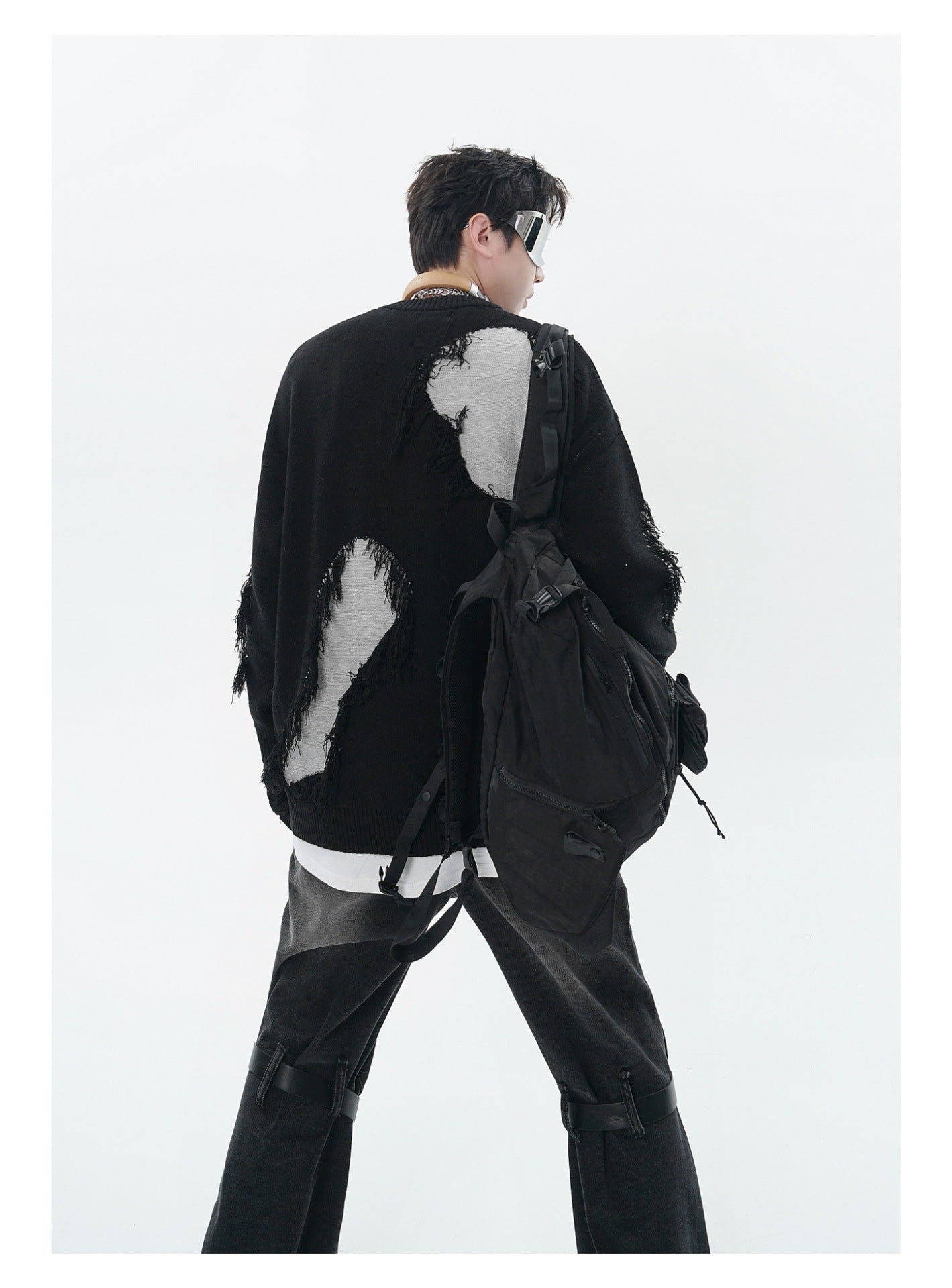 Unisex Streetwear Sweater With Irregular Pattern And Fringe Details showcased on a model with a stylish backpack