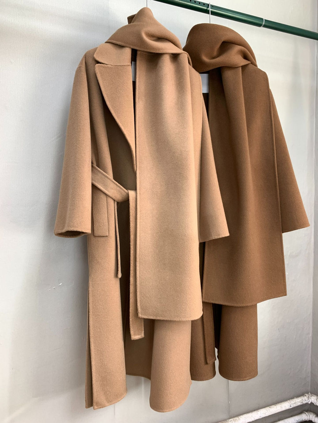 Urban Drift Double Face Wool Scarf Coat Camel and Caramel Edition hanging on a rack, showcasing elegant design and soft fabric