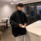 Model masculin in pulover negru oversized in interior modern scriind in caiet Pulover cu guler lazy style loose