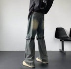 Model văzut din spate purtând Blugi prespălați retro cu detaliu din metal. Croială largă, buzunare și curele la genunchi.