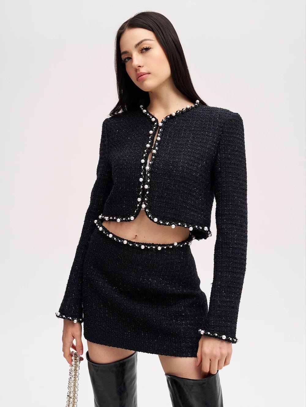 Model showcasing the Valeria Tweed Set Jacket, Bra, Skirt in black with pearl detailing for a chic look