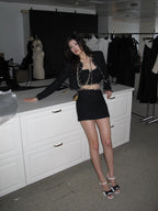 Model wearing Valeria Tweed Set Jacket, Bra, Skirt in black with stylish accessories and high heels