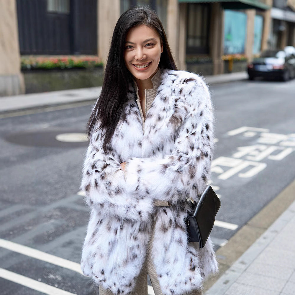 Woman wearing a White Luxe Lynx Coat, smiling on a city street with a stylish handbag