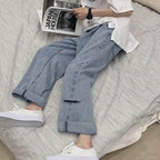Casual outfit featuring Wide Jeans with Folded Hem and Rips paired with white sneakers on a bed
