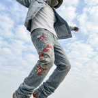 Model wearing Wildflight Embroidered Jeans with vibrant floral designs on a cloudy day
