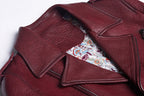 Close-up of women's wine leather moto jacket featuring intricate patterned lining for stylish allure