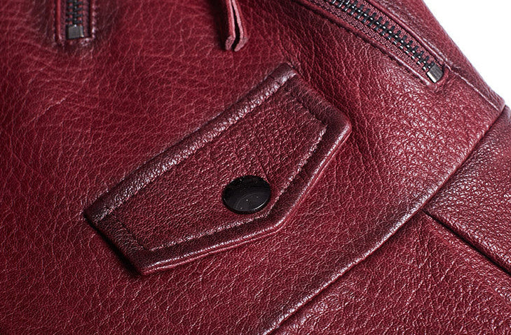 Close-up of a women's wine leather moto jacket featuring snap buttons and detailed stitching