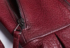 Close-up of women's wine leather moto jacket showcasing detailed zipper and texture